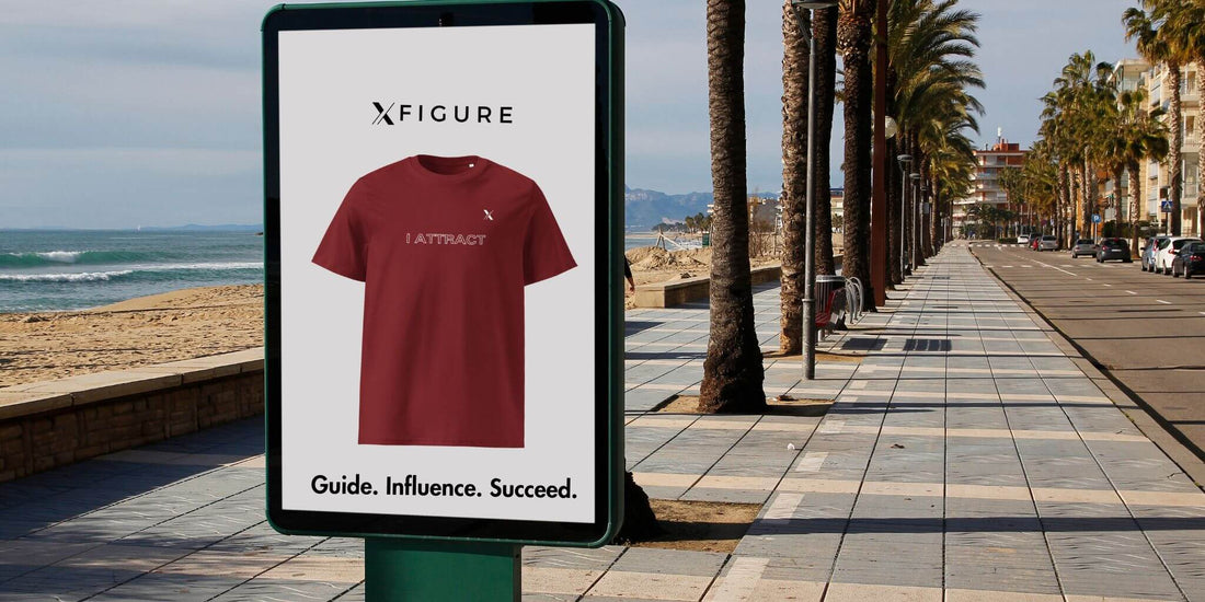 Red “I Attract” T-shirt from Xfigure Empower Line displayed by the beach. Symbolizing influence and success.